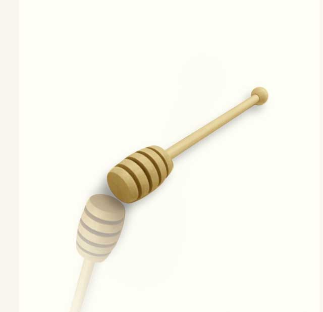A wooden honey drizzler on a white background.